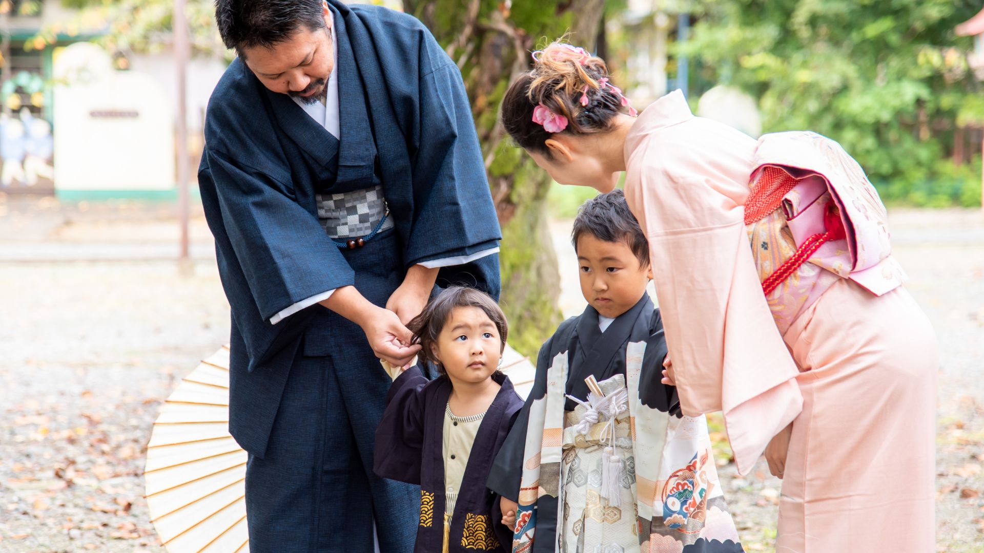 Photo of a Japanese family of four: mom, dad, and two boys. They are dressed in traditional kimono.