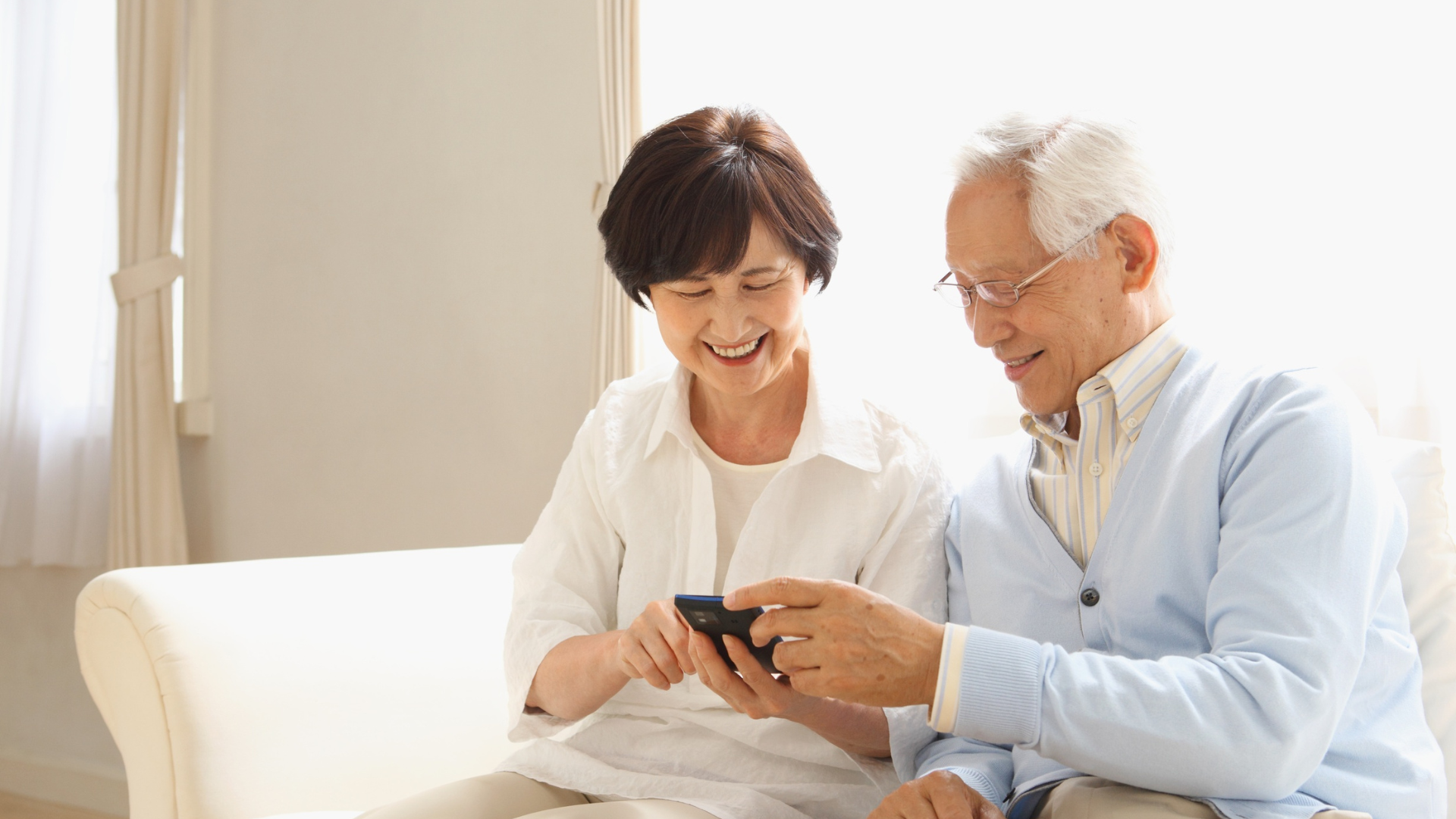 Elderly couple sharing a smartphone.